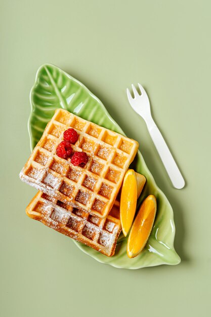 Leuk bord in de vorm van een tropisch blad met wafels en fruit. eten idee voor kinderen. ontbijt voor kinderen.