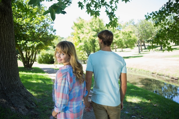 Leuk hartelijk paar die hand in hand in het park lopen