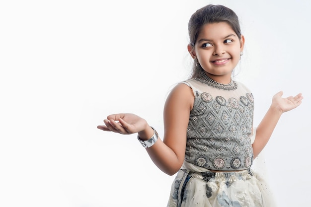Leuk indisch meisje in etnische slijtage en het tonen van uitdrukking over witte achtergrond