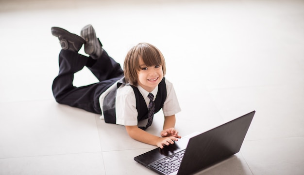 Leuk jong geitje met laptop op grond thuis