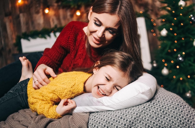 Leuk kinderspel met ouders binnen op een bed met warme plaids