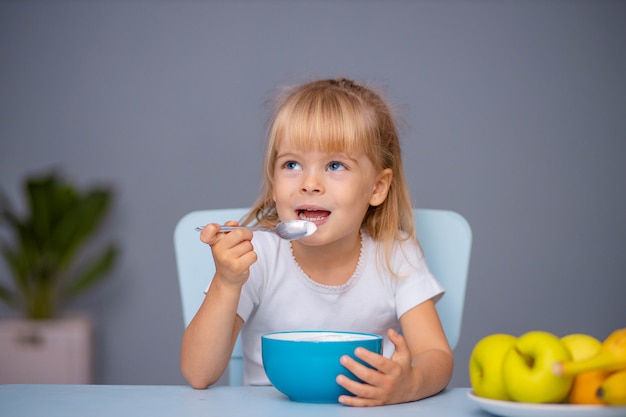 Leuk klein kindmeisje dat binnen yoghurt eet