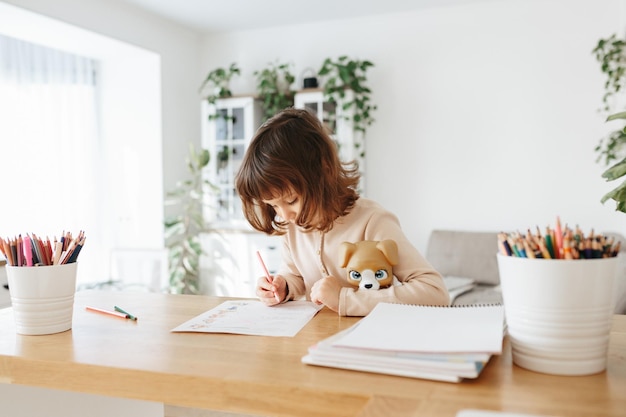 Leuk kleutermeisje dat thuis leert Thuisonderwijs op afstand voor kinderen