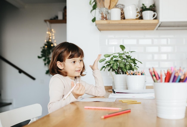 Leuk kleutermeisje dat thuis leert Thuisonderwijs op afstand voor kinderen