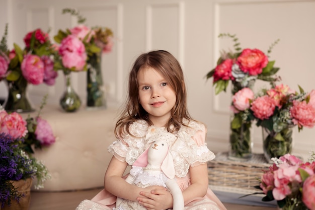 Leuk lief meisje in een mooie roze kanten jurk met bloemen