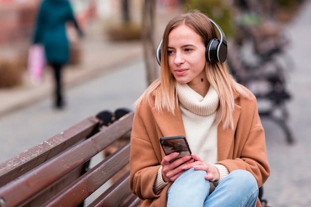 Leuk meisje dat aan muziek op hoofdtelefoons luistert