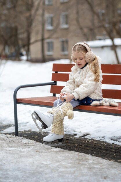 Leuk meisje dat schaatsen aantrekt voor schaatsen in de winter buiten Winter entertainment vrijetijdsbesteding