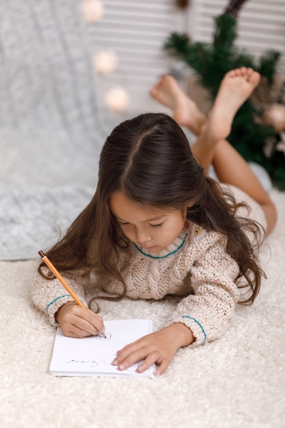 Leuk meisje dat thuis een brief aan de Kerstman schrijft