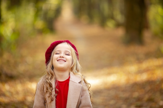 Leuk meisje in rode baret op een wandeling in de herfst