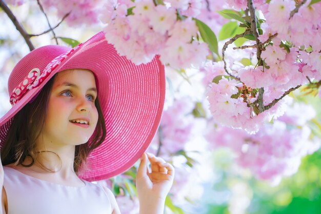 Leuk meisje in roze hoed De tienerportret van de lente