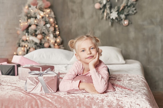 Leuk meisje op het bed met Kerstmisdecoratie