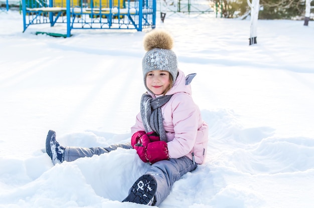 Leuk meisje speelt met sneeuw in de winter. Winter engel