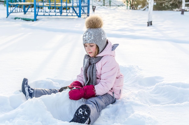 Leuk meisje speelt met sneeuw in de winter. Winter engel