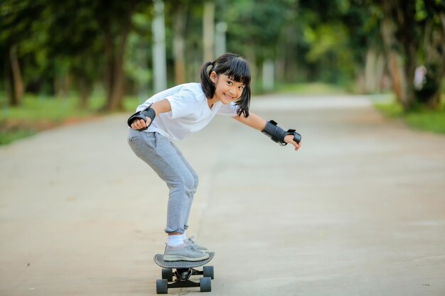 Leuk meisje uit Azië dat skateboardt of surft in het skatepark.