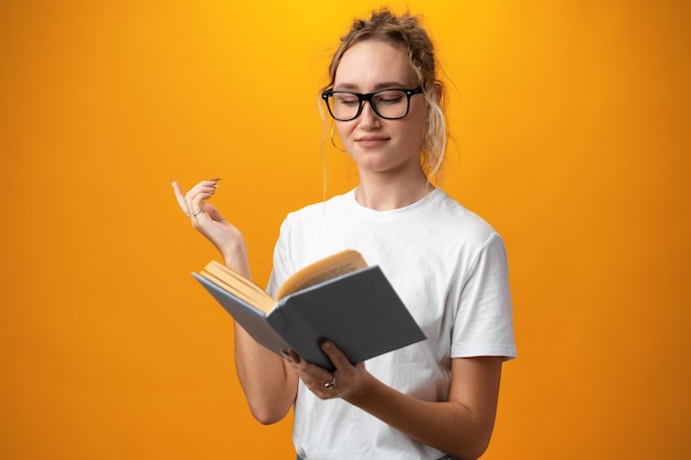 Leuk mooi meisje met boeken op gele achtergrond