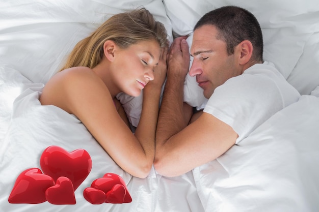 Leuk paar die in bed in slaap tegen liefdeharten liggen