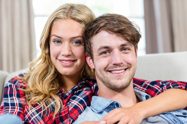 Leuk paar knuffelen op de bank in de woonkamer