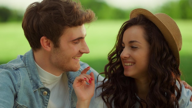 Leuk paar zittend op weide Gelukkige man en vrouw die buiten lachen