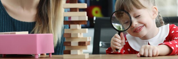 Leuk peutermeisjeshorloge door vergrootglas op houten toren