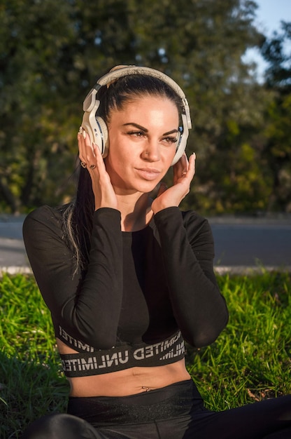 Leuk sportief meisje dat naar muziek luistert met haar koptelefoon./Mooie jonge brunette vrouw luistert naar muziek.