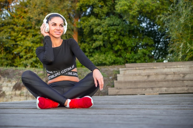 Leuk sportief meisje, luisteren naar muziek met koptelefoon./Fitness vrouw met koptelefoon.