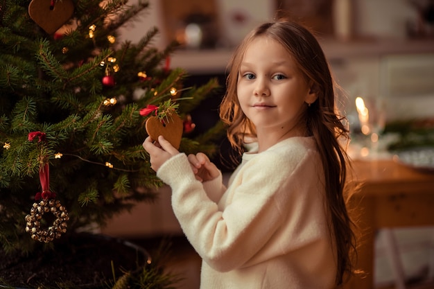 Leuk vrolijk meisje dichtbij de kerstboom