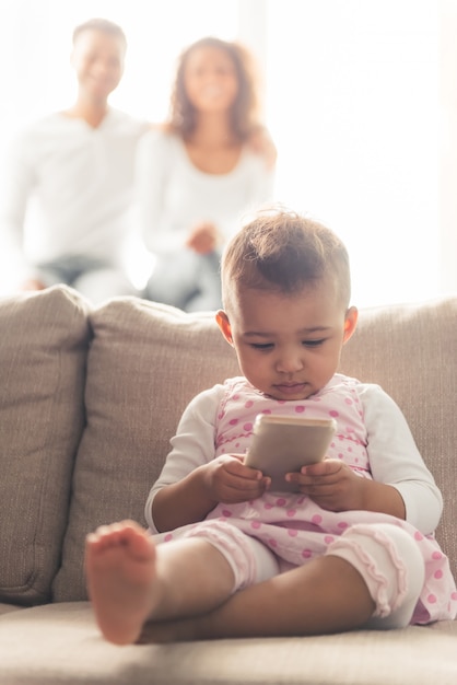 Leuke Afro-Amerikaanse baby gebruikt een slimme telefoon.