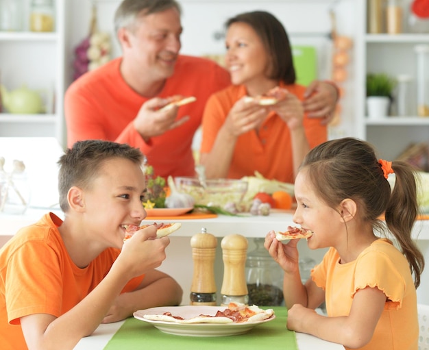 Leuke broer en zus die samen salade proeven in de keuken