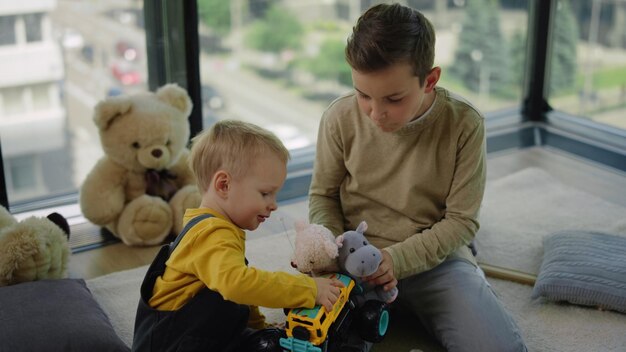 Leuke broers die thuis samen spelen Charmante kinderen die binnenshuis gek doen