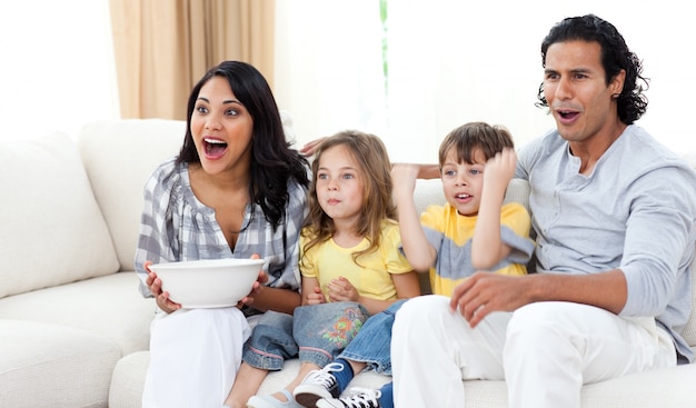 Leuke broers en zussen die tv kijken met hun ouders