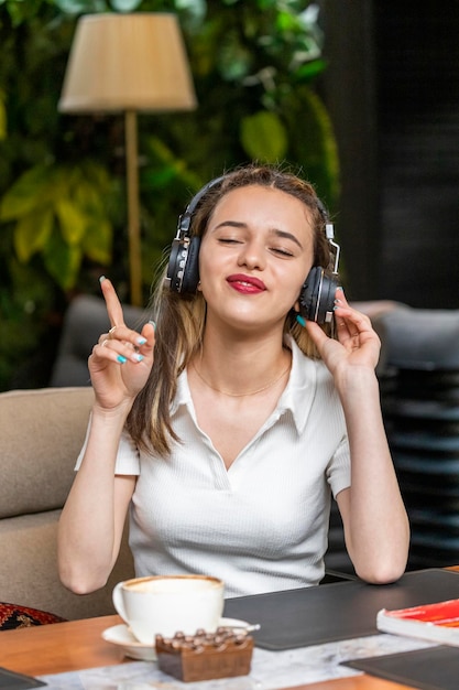 Leuke dame die muziek luistert met haar koptelefoon en zich gelukkig voelt