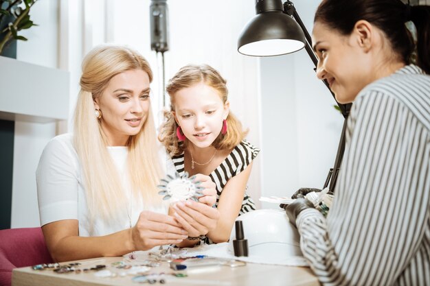 Leuke dochter. schattige blondharige dochter die haar moeder aanbeveelt om kleur voor haar nagels te kiezen