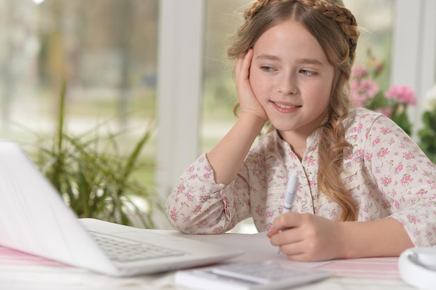 Leuke en gelukkige kleine meisjes die een laptop gebruiken.