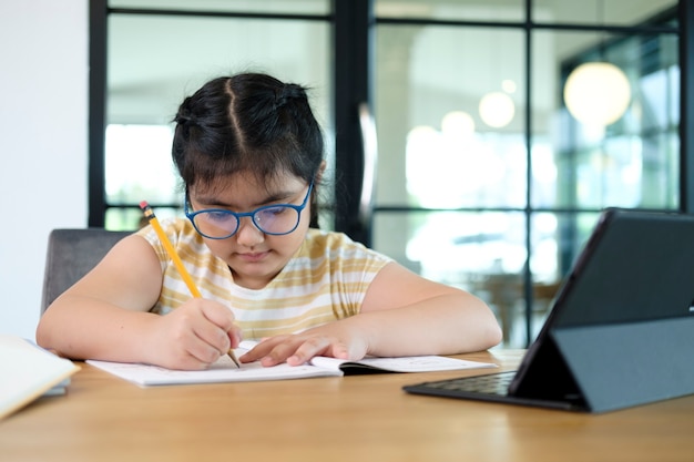 Leuke en gelukkige kleine meisjeskinderen die laptopcomputer gebruiken, die via online e-learningsysteem studeren.