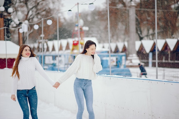 Leuke en mooie meisjes in een witte trui in een winterstad.