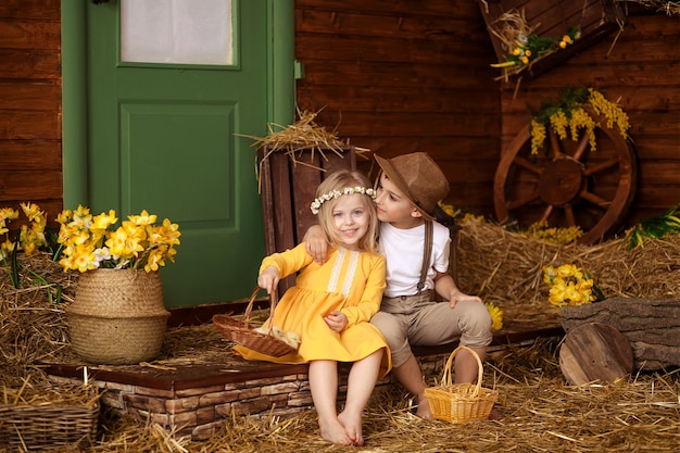 Leuke gelukkige kleine kinderen, een jongen en een meisje in de kribbe met de dieren op de dag van Pasen.