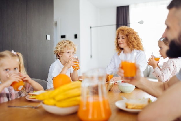 Leuke gezellige familie die samen sinaasappelsap drinkt