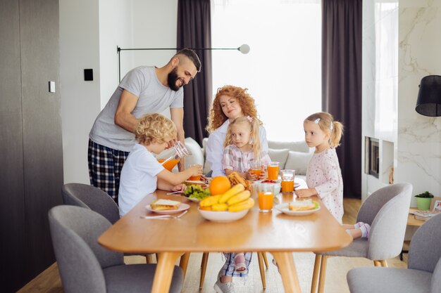 Leuke gezellige familie wachtend op het sap