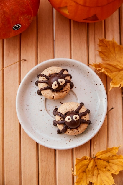 Leuke grappige spinnenkoekjes met halloween-pompoen tussen herfstbladeren trick or treat handgemaakte koekjes