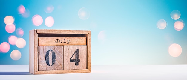 Leuke houten kalender met vierde juli-datum op blauwe hemelachtergrond als achtergrond voor ons onafhankelijkheidsdag