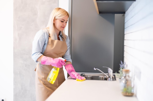 Leuke huisvrouw die de keuken schoonmaakt