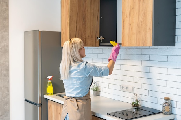 Leuke huisvrouw die de keuken schoonmaakt