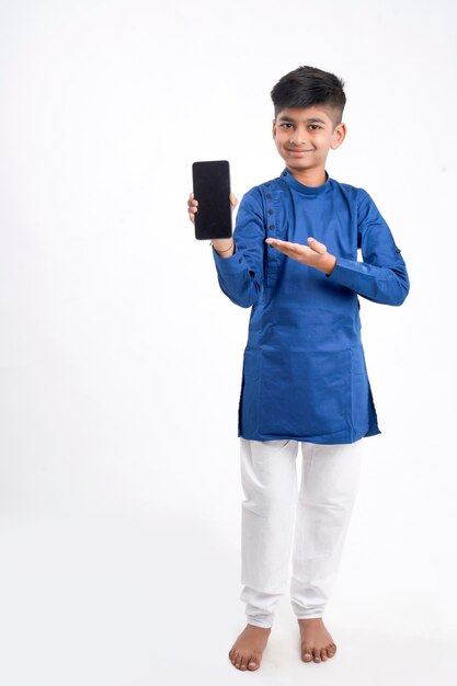 Leuke indische kleine jongen die het slimme telefoonscherm op wit toont