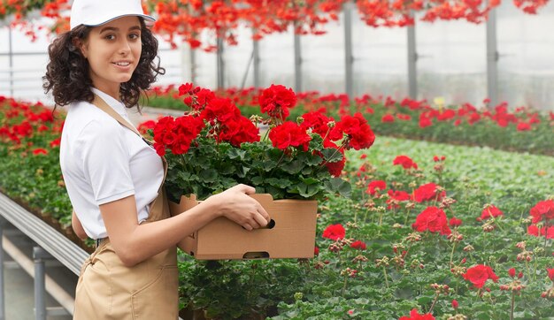 Leuke jonge vrouw verzamelt bloemen te koop