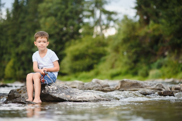 Leuke jongen die in de rivier vist