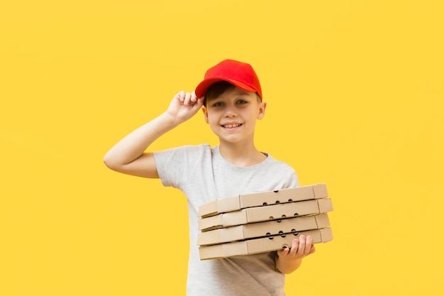 Leuke jongen die pizzadozen houdt