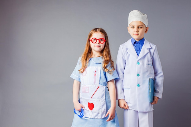 Leuke jongen en meisje in medisch uniform spelen als dokters