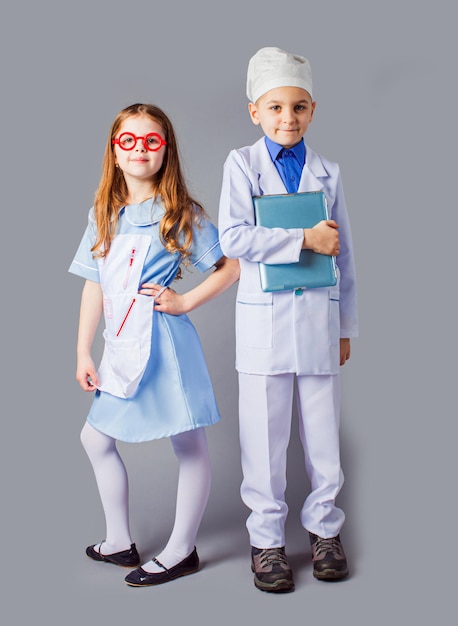 Leuke jongen en meisje in medisch uniform spelen als dokters