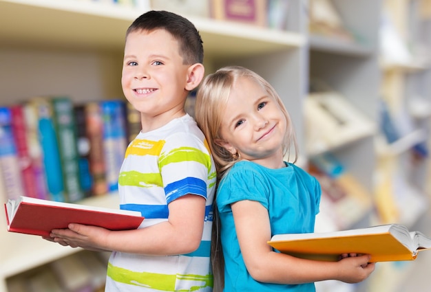 Leuke jongen en zijn zusje met boeken