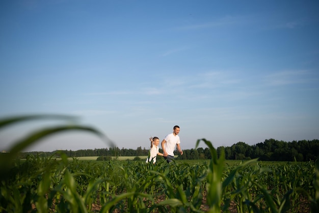 Leuke jongen in een korenveld met vader die een vliegtuig lanceert